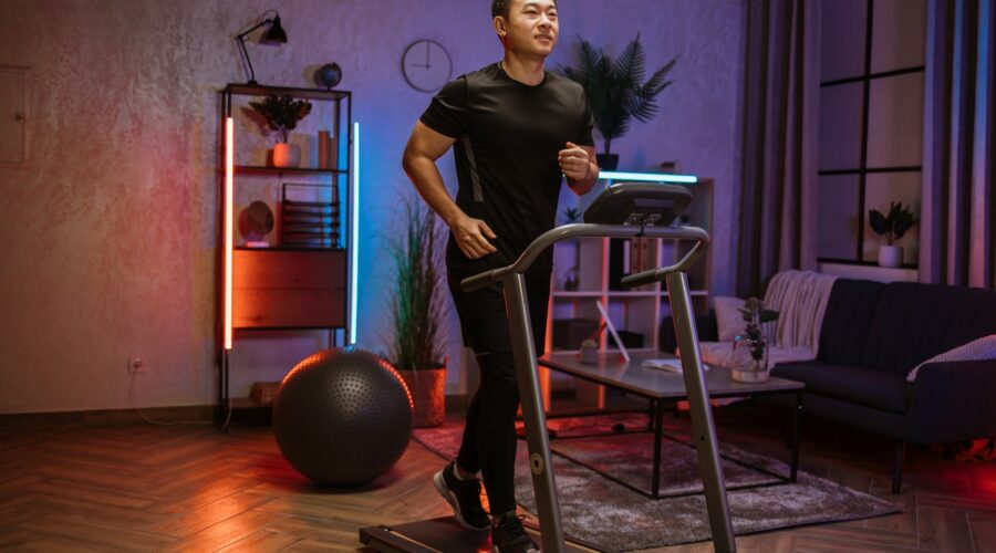 Attractive young sports asian man doing fitness exercise, running on treadmill .