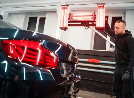 Detailing worker with infrared lamps near the car. Car detailing concept