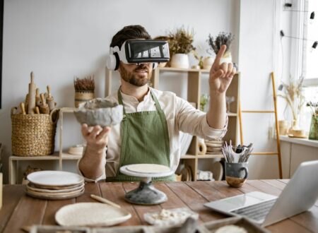 Man using virtual reality glasses to sculpt pottery in studio