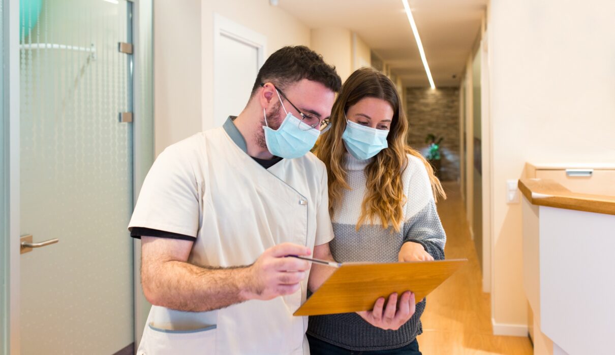 Nurse explaining notes to female patient in health center