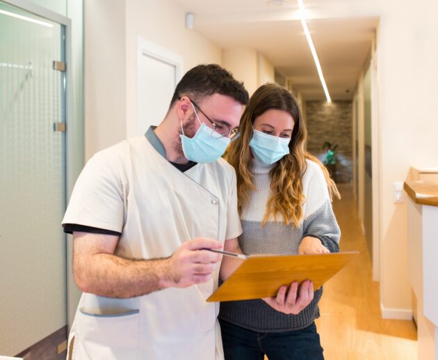 Nurse explaining notes to female patient in health center