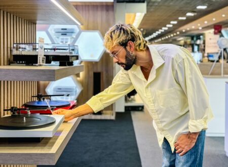 Stylish man choosing modern turntable in tech store