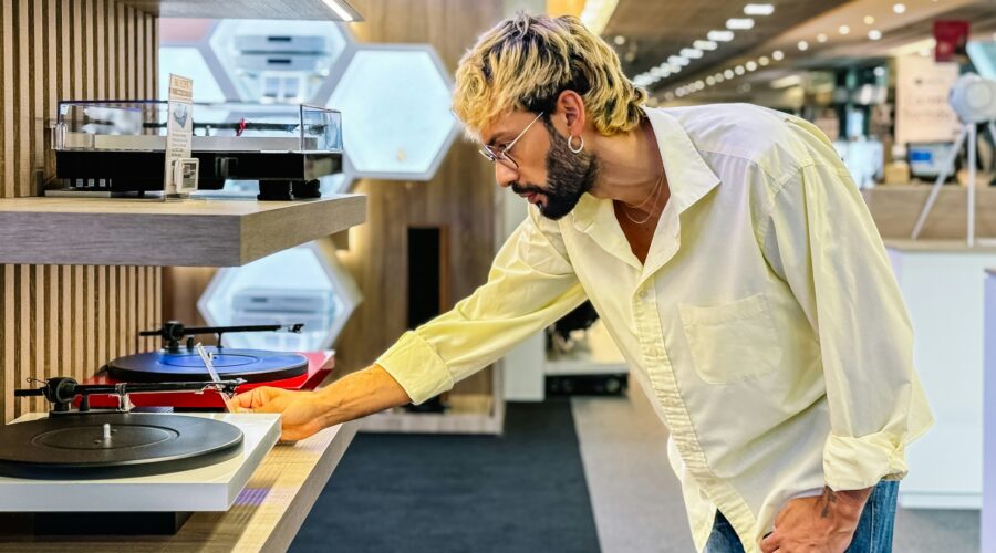 Stylish man choosing modern turntable in tech store