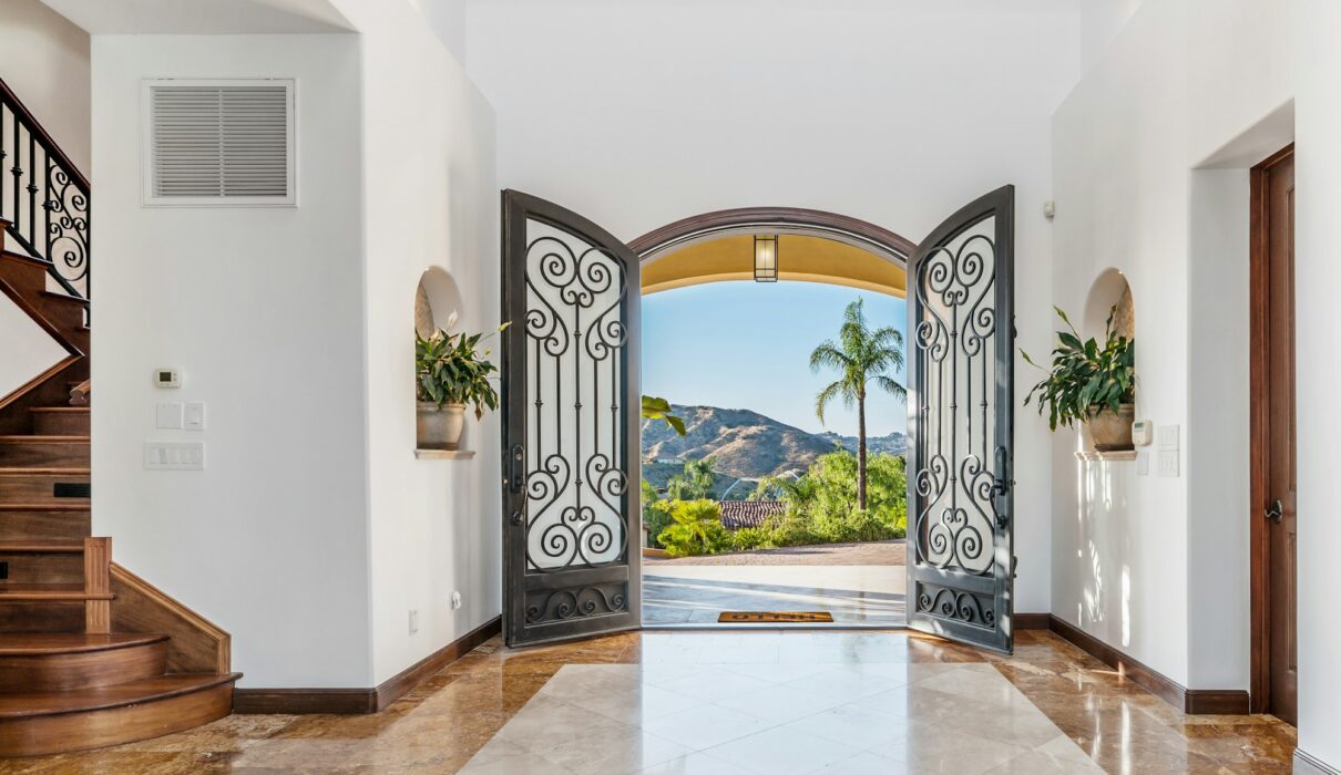 the entry way to a luxurious residence in the mountains is lined with marble floors