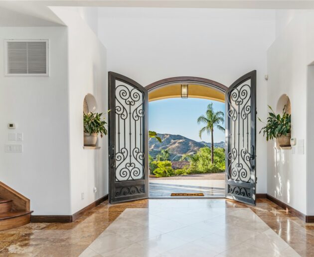 the entry way to a luxurious residence in the mountains is lined with marble floors