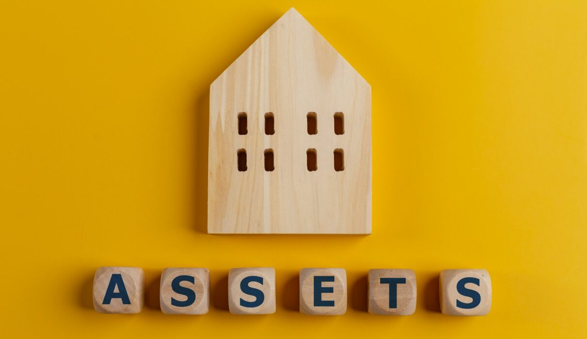 The word assets written on wooden cubes with assets icon on yellow background. Asset management