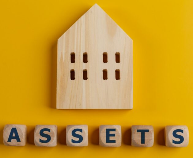 The word assets written on wooden cubes with assets icon on yellow background. Asset management