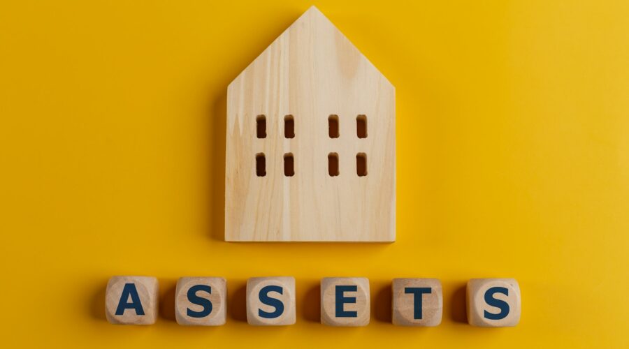 The word assets written on wooden cubes with assets icon on yellow background. Asset management