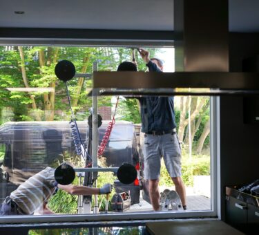 Window installers removing old, inefficient windows from a home during home improvement project.