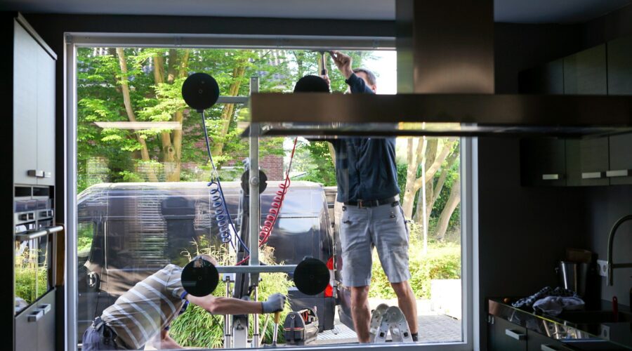 Window installers removing old, inefficient windows from a home during home improvement project.