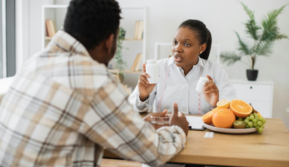 Woman with food supplements chatting with man in hospital