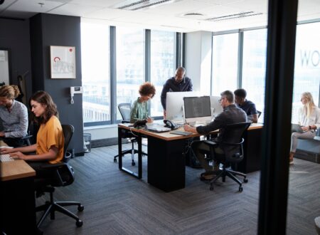 Young creative team working together at computers in a casual office, seen from doorway