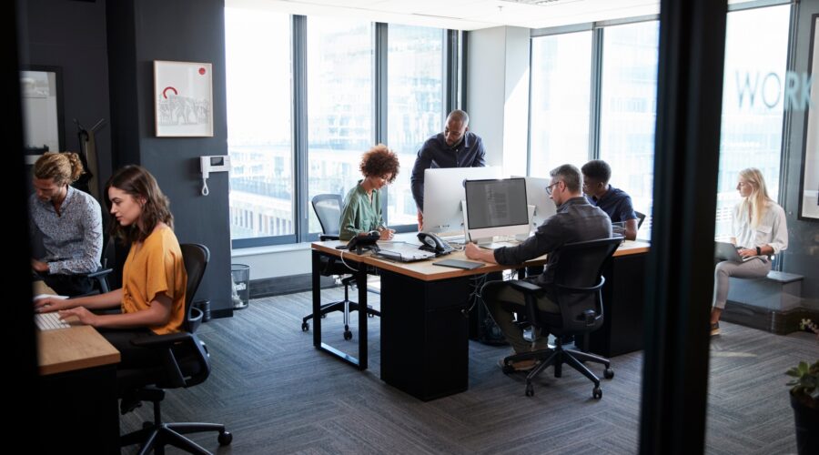 Young creative team working together at computers in a casual office, seen from doorway